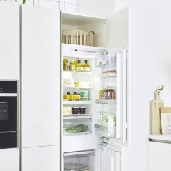 geöffneter Kühlschrank in weißer Küche