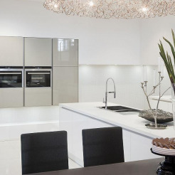 Elegante grifflose Küche mit Einbaugeräten, Designerlampe und Kücheninsel