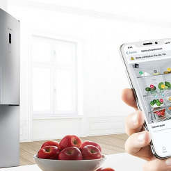 geöffneter Bosch Kühlschrank gekoppelt mit dem Smartphone per Home Connect App