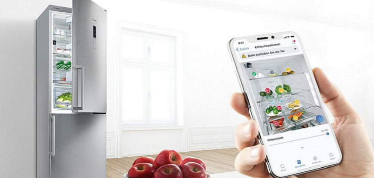 geöffneter Bosch Kühlschrank gekoppelt mit dem Smartphone per Home Connect App