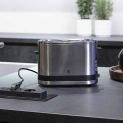 Toaster-Stromkabel steckt in versenkbarer Steckdose in der Arbeitsplatte