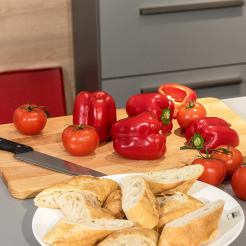 Holzbretter mit roten Tomaten und Paprikaschoten und Schneidemesser