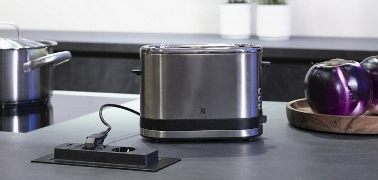 Toaster-Stromkabel steckt in versenkbarer Steckdose in der Arbeitsplatte