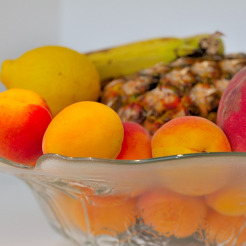 Obstschale mit Aprikosen, Pfirsich, Zitrone und Ananas