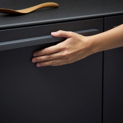 Hand auf schwarzem Küchenschrank von LEICHT hinterlässt keine Fingerabdrücke