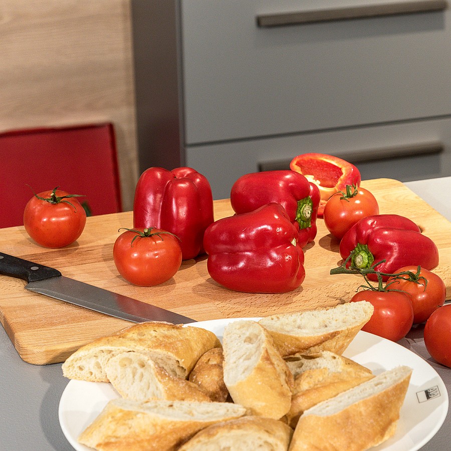 Holzschneidebrett mit Tomaten und roten Paprikaschoten