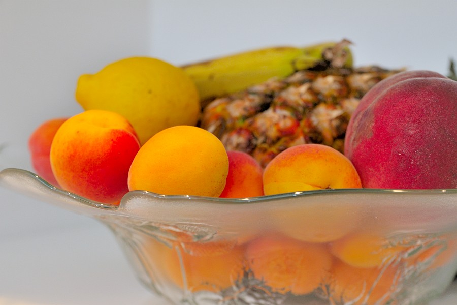 Obstschale mit Aprikosen, Pfirsich, Zitrone und Ananas