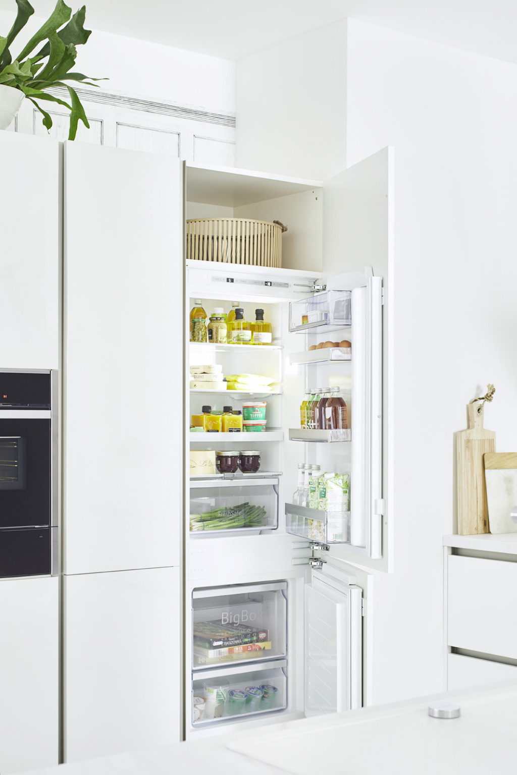 geöffneter Kühlschrank in weißer Küche