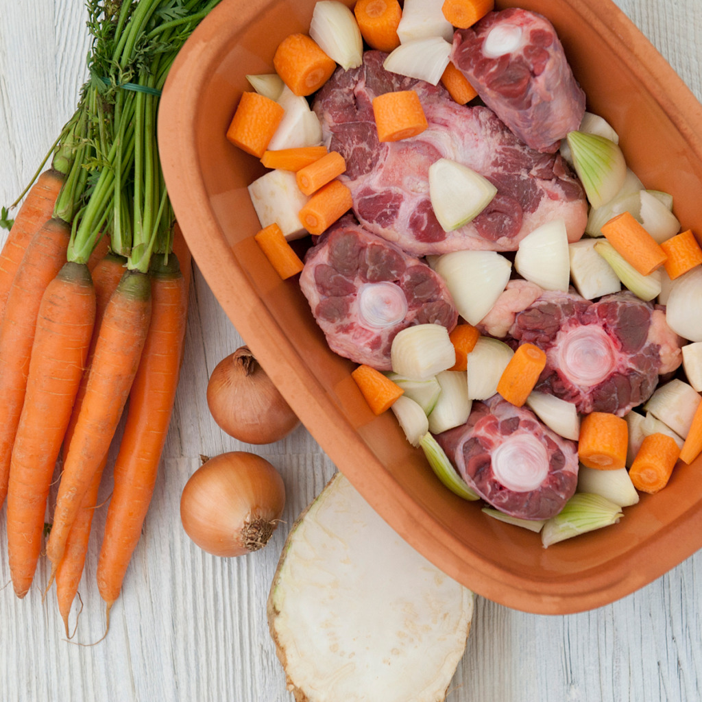 Römertopf mit Gemüse und Fleisch befüllt
