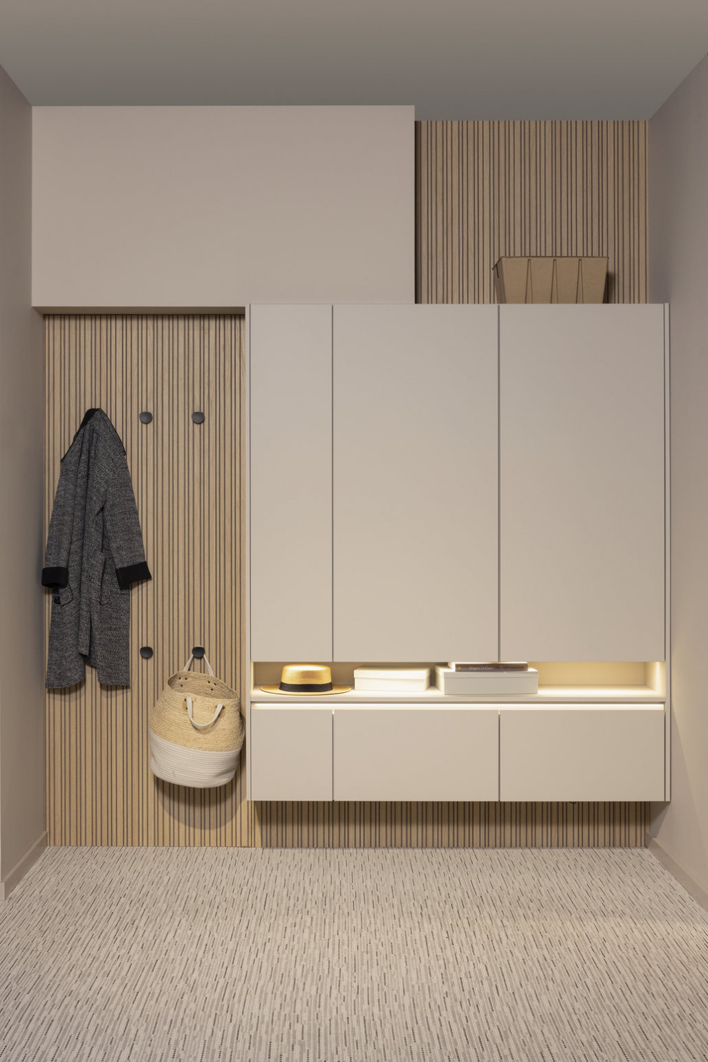 Garderobenbereich an der Flur-Stirnseite, gestaltet mit Nischenrückwand, Beschlägen und wohnlichem Küchenhängeschrank