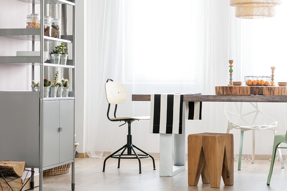 Essbereich in der offenen Wohnküche im Boho-Style mit verschiedenen Stühlen, bunt gemusterten Textilien und offenen Regalen