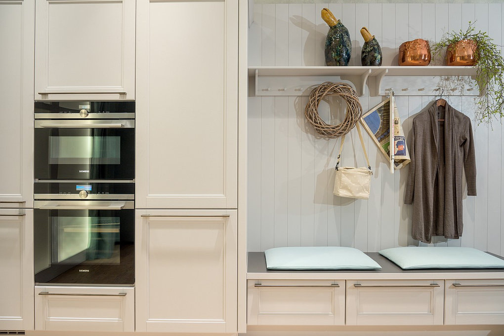 Sitznische mit Garderobenhaken in heller Landhausküche